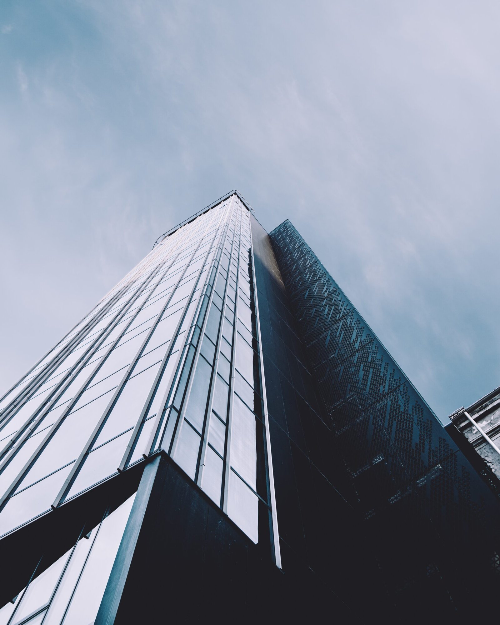 A vertical low angle shot of a high rise building in a glass facade